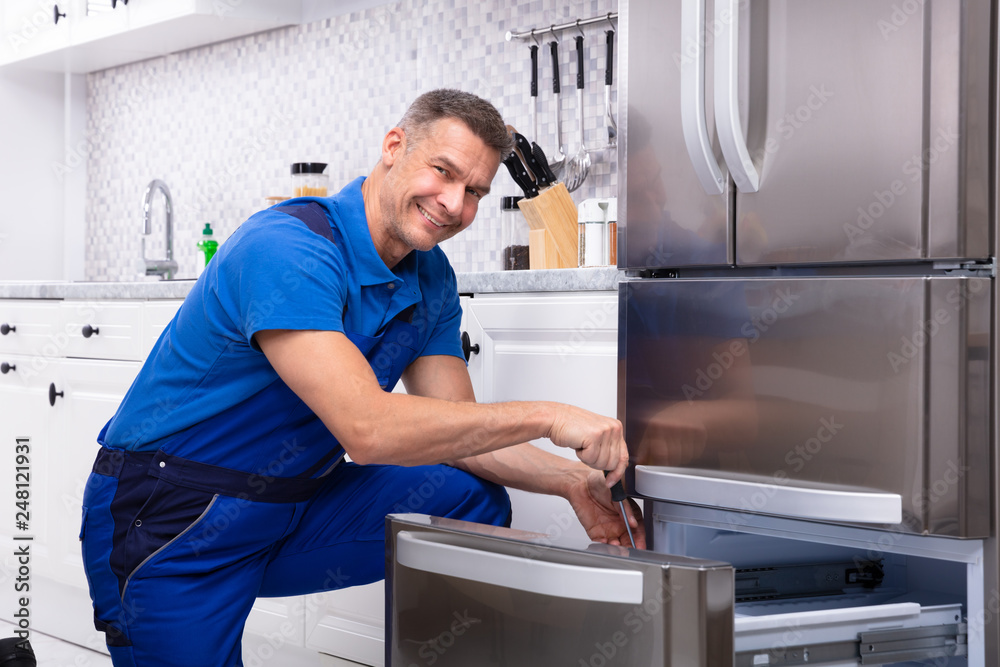 Serviceman Repairing Refrigerator Serviceman Repairing Refrigerator