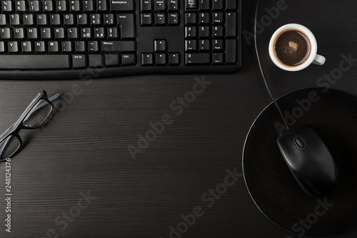 Total black desk with desktop and cup of coffee