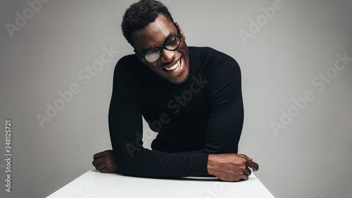 Cheerful african man sitting at table