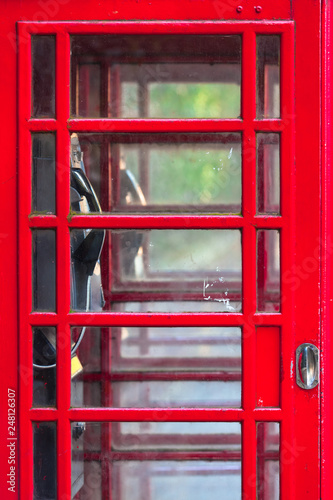 Telephone Booth Door Close Up / Detail of double red vintage english phone box, many small glass windows at door, interior view inside through it (copy space)