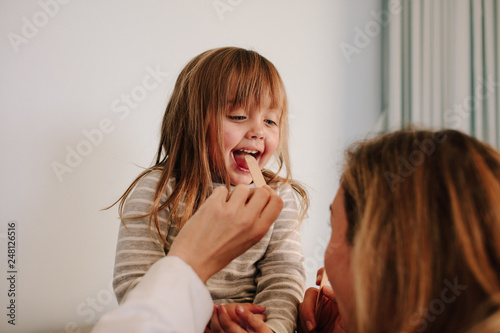 Картината върху платно Doctor checking little girl's throat