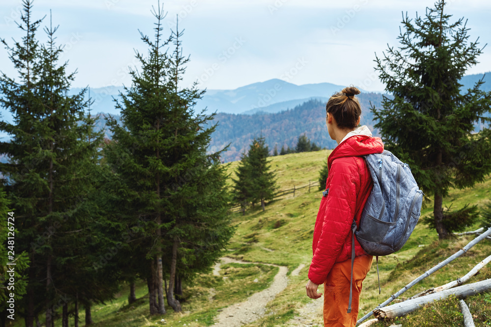 Naklejka premium woman hiker with backpack walking outdoors in mountains