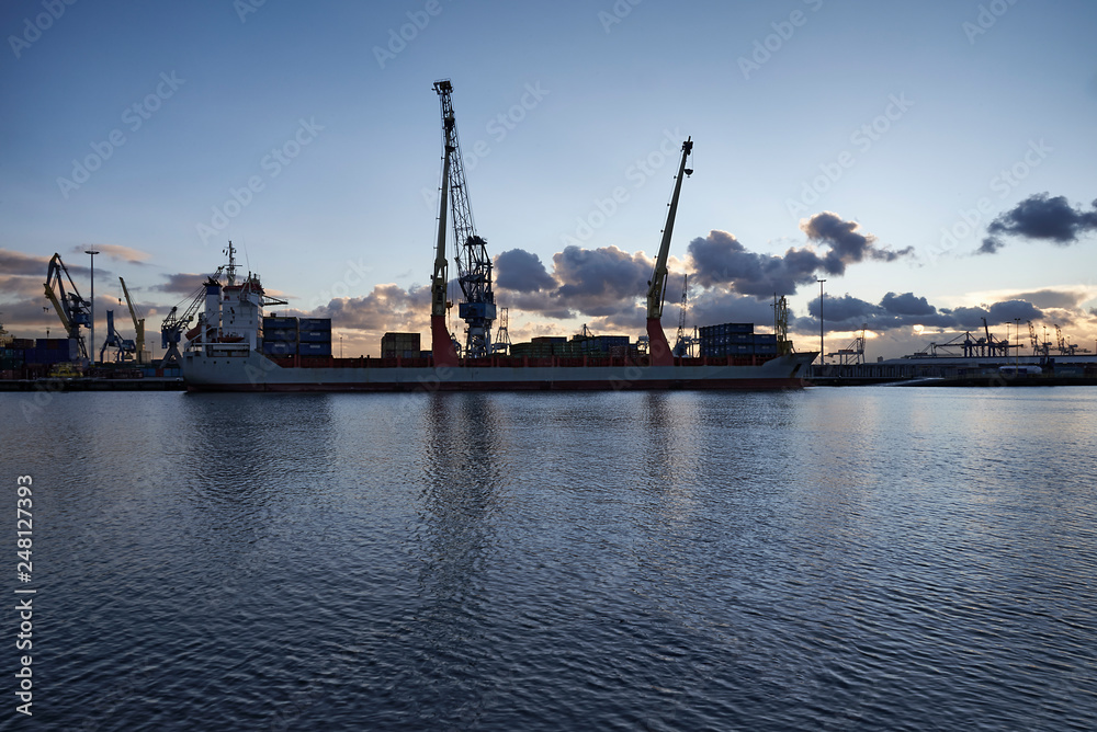 Cranes at work loading and unloading ships at the Port of Rotterdam Cranes at work loading and unloading ships at the Port of Rotterdam