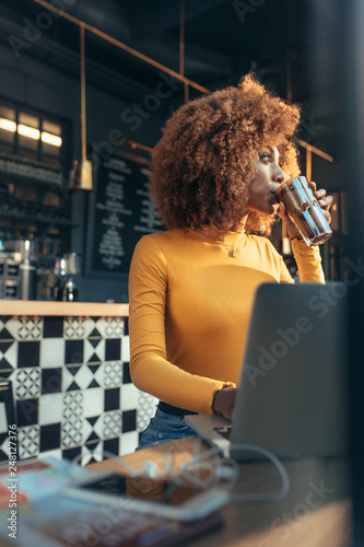 Female freelancer drinking chocolate shake at a coffee shop