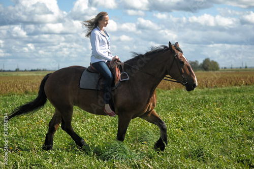 blonde riding a horse in a field