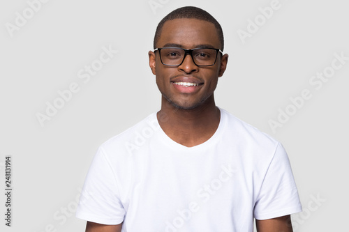 Smiling african millennial man looking at camera isolated on background