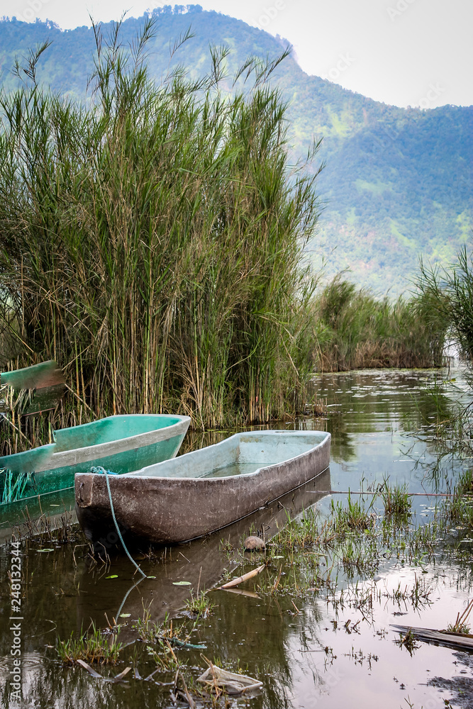 Obraz premium BALI, INDONESIA - November 23, 2013: Wooden boats near 99Pura Ulun Danu Bratan, Hindu Temple on Bratan Lake in Bali, Indonesia.
