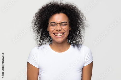 Funny african woman laughing isolated on white grey studio background