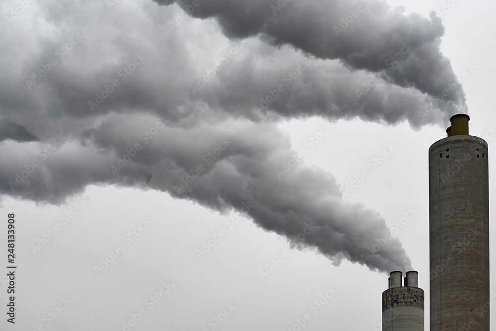 Chimney of a factory blowing greenhouse gas emissions in the air Stock