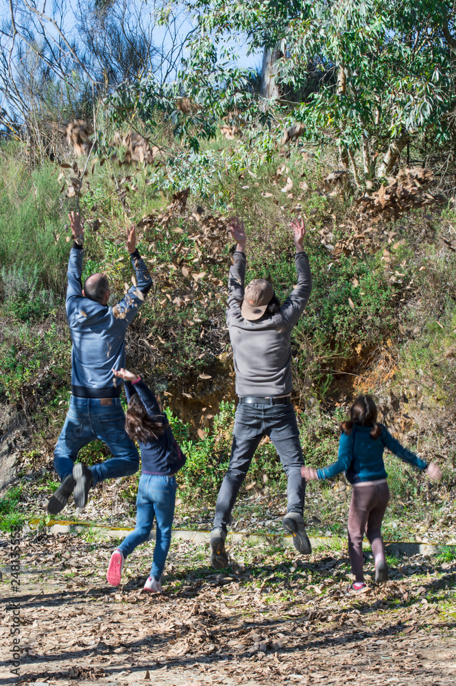 Gente saltando, levitando y lanzando hojas secas hacia arriba / People