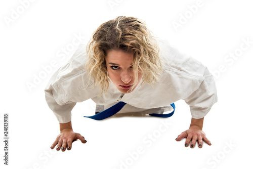 Full body of woman wearing martial arts outfit standing in plank