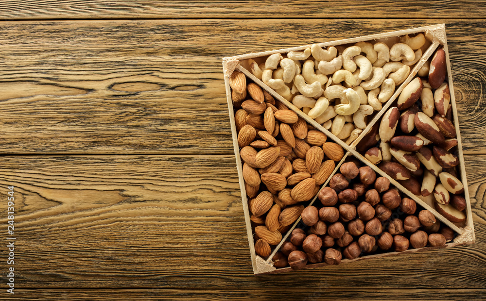 Assorted nuts. Set of nuts top view. Wooden table top. Texture background. Place for advertising text. Assorted nuts. Set of nuts top view. Wooden table top. Texture background. Place for advertising text.