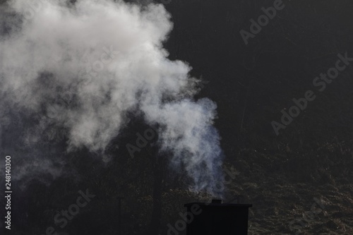 White smoking chimney with a dark background