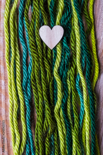 Coeur en bois sur un fond en laines vertes