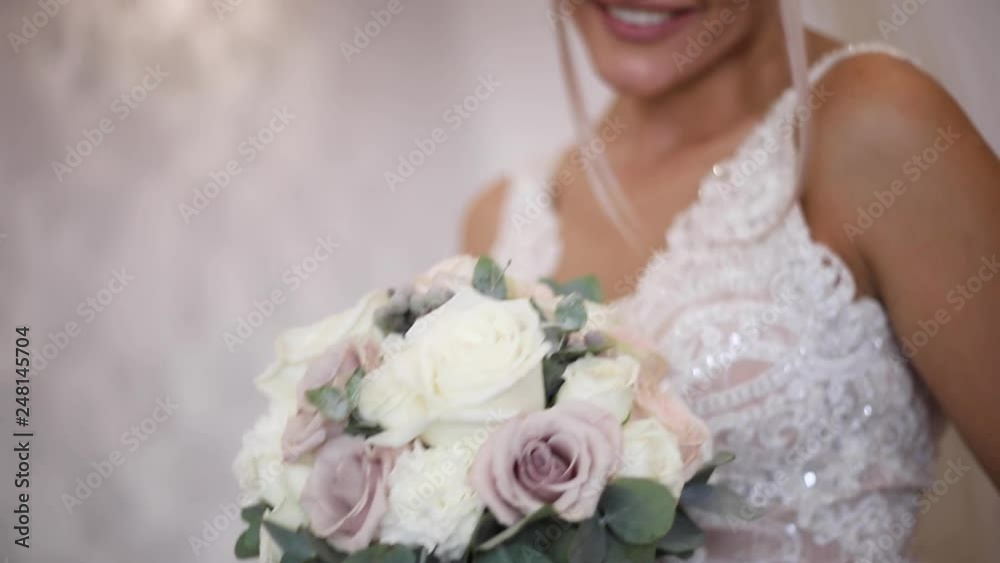 Elegant bride hold a wedding bouquet in hands. Beautiful blond hair girl with fashion makeup and hairstyle. Women model at the hotel Elegant bride hold a wedding bouquet in hands. Beautiful blond hair girl with fashion makeup and hairstyle. Women model at the hotel