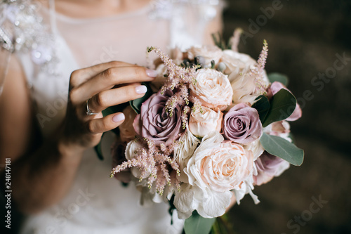 The bride holds a beautiful wedding bouquet of pink and white flowers in her han Fotobehang