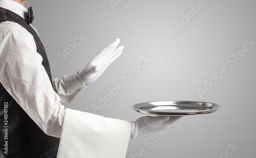 Waiter serving with white gloves and steel tray in an empty space
 photo