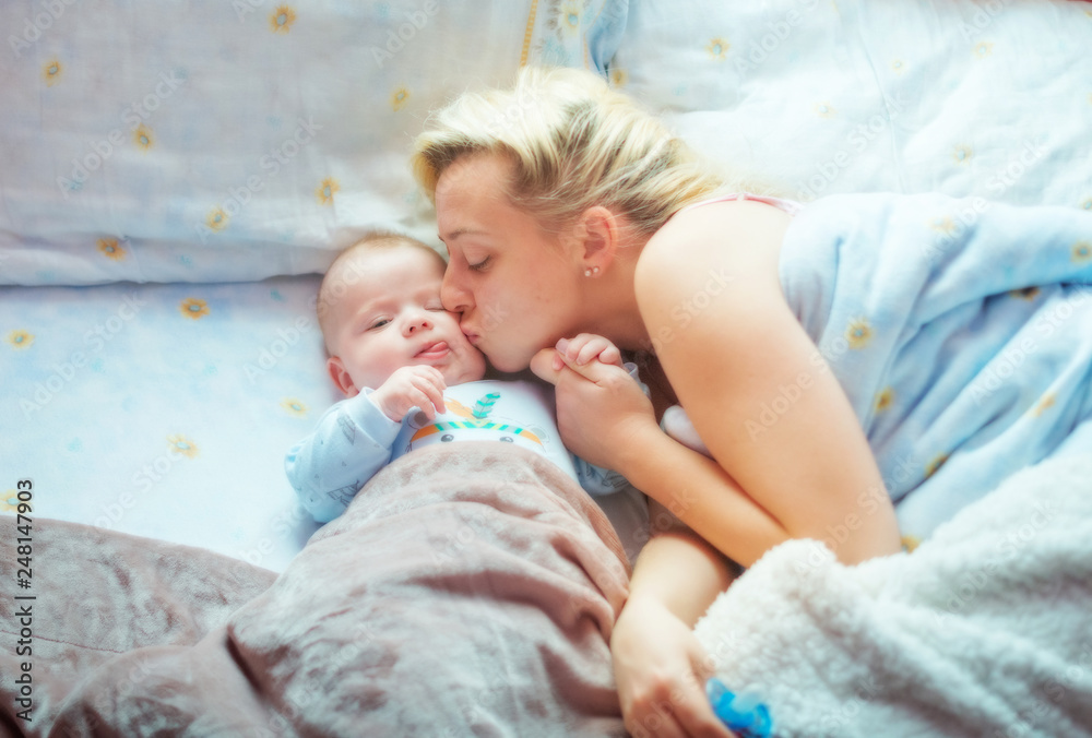 happy mother is sleeping with her baby in bed, happy family, motherhood happy mother is sleeping with her baby in bed, happy family, motherhood