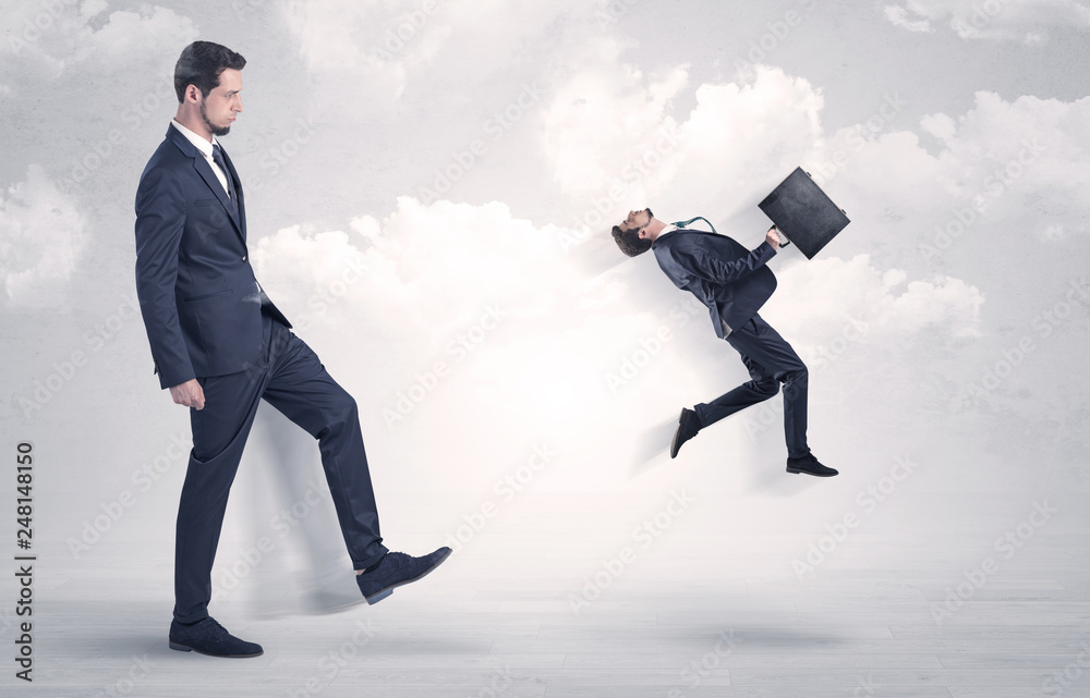 Big businessmen kicking himself as a small employee with cloudy background
Big businessmen kicking himself as a small employee with cloudy background