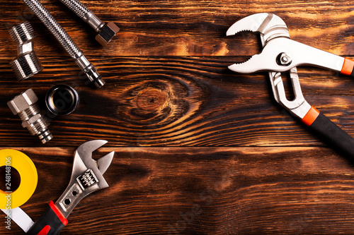 Plumbing tools and fixtures on a dark wooden background. Close-up