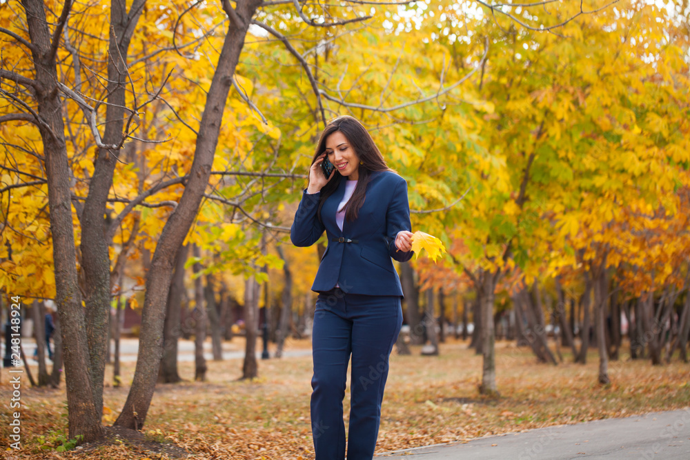 Happy arab businesswoman in blue suit walking in autumn park Happy arab businesswoman in blue suit walking in autumn park