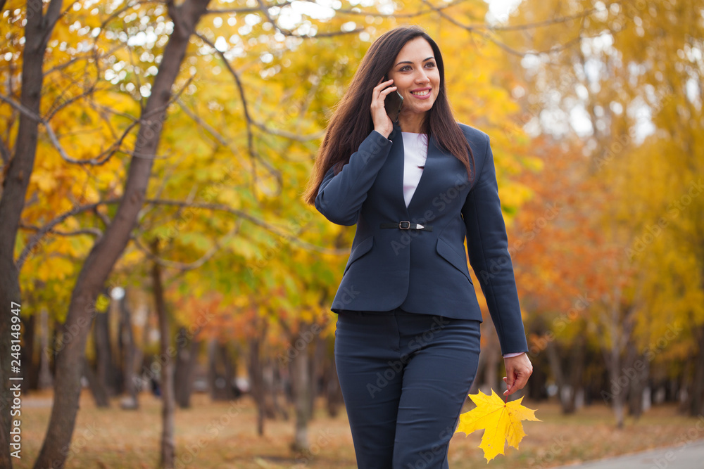 Happy arab businesswoman in blue suit walking in autumn park Happy arab businesswoman in blue suit walking in autumn park