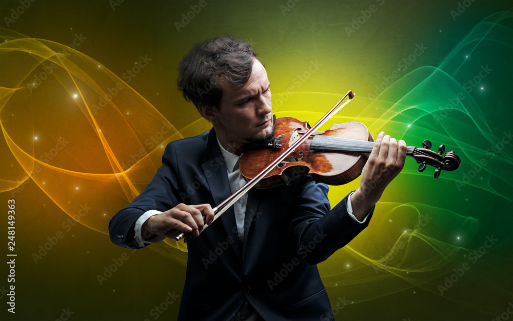Fototapeta premium Serious classical violinist with fabled sparkling wallpaper