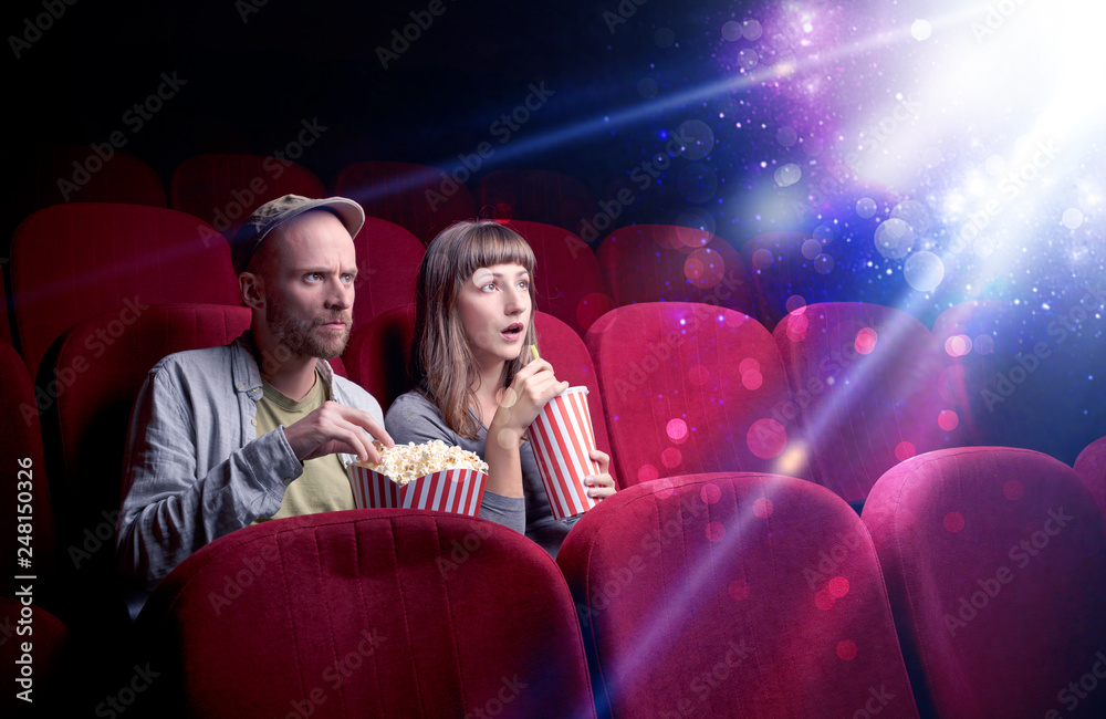 Obraz premium Romantic couple cuddling and watching the miraculous part of the film