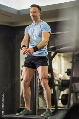 Image of a muscular man doing high knees exercises at the gym.