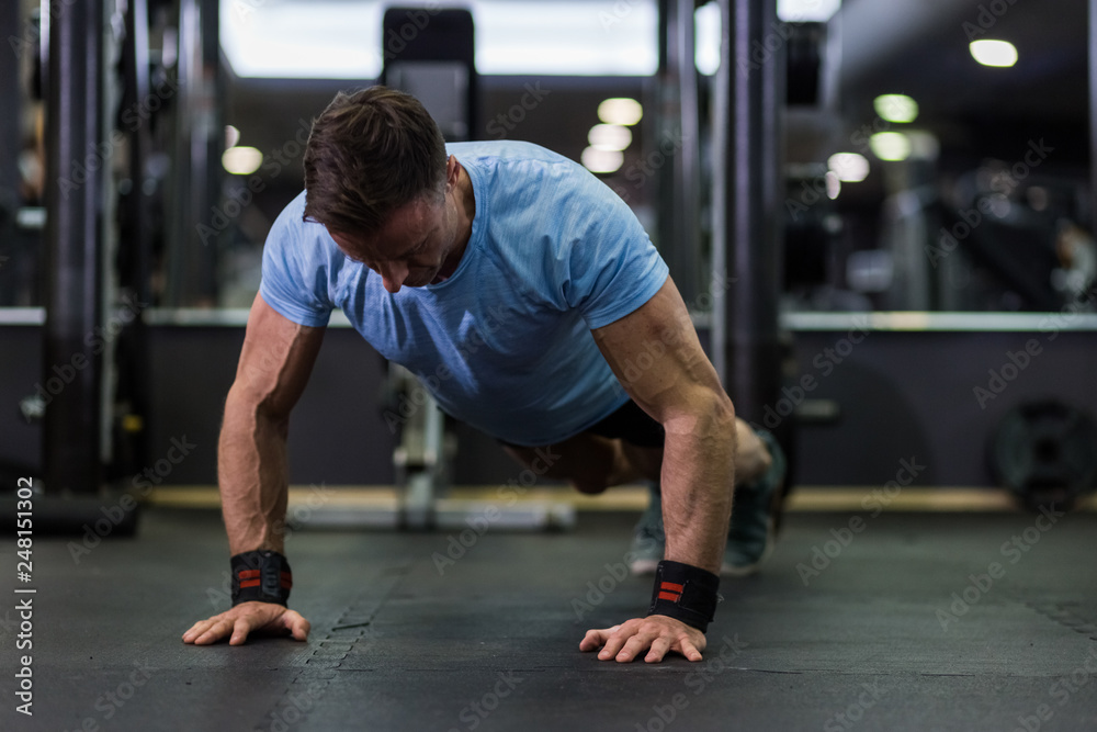 Image of an attractive man doing push-up at the gym. Image of an attractive man doing push-up at the gym.