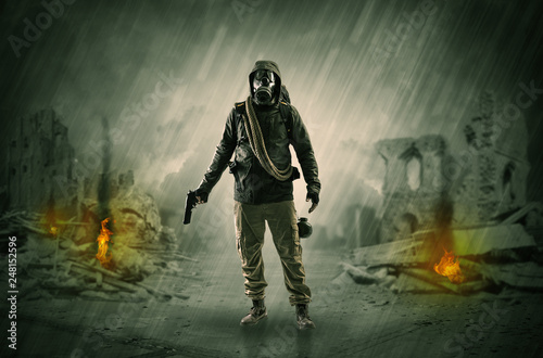 Destroyed place after a catastrophe with man in gas mask and weapon on his hand
