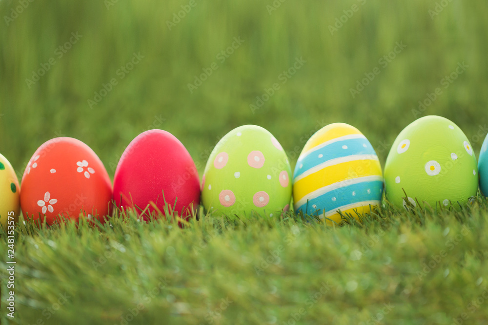 easter, holidays and tradition concept - row of colored eggs on artificial grass easter, holidays and tradition concept - row of colored eggs on artificial grass