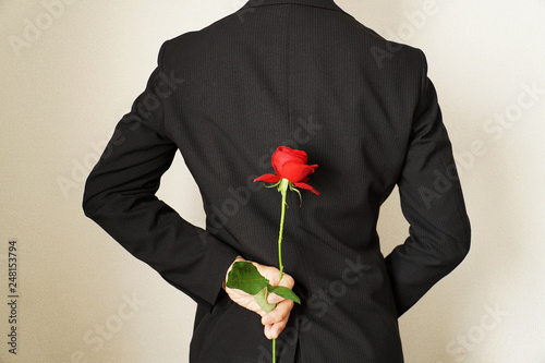Fototapeta Naklejka Na Ścianę i Meble -  薔薇の花を隠し持つスーツの男性