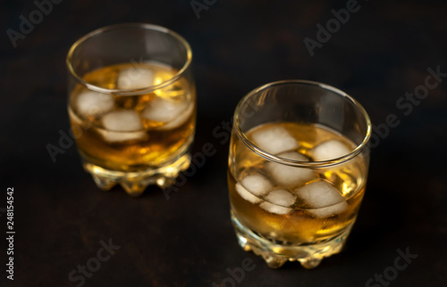 two glasses of whiskey with ice on the concrete