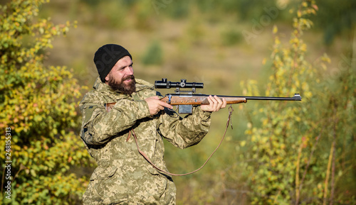 Hunter hold rifle. Bearded hunter spend leisure hunting. Focus and concentration of experienced hunter. Hunting masculine hobby concept. Man brutal gamekeeper nature background. Regulation of hunting