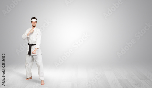 Young kung-fu trainer fighting in an empty space 