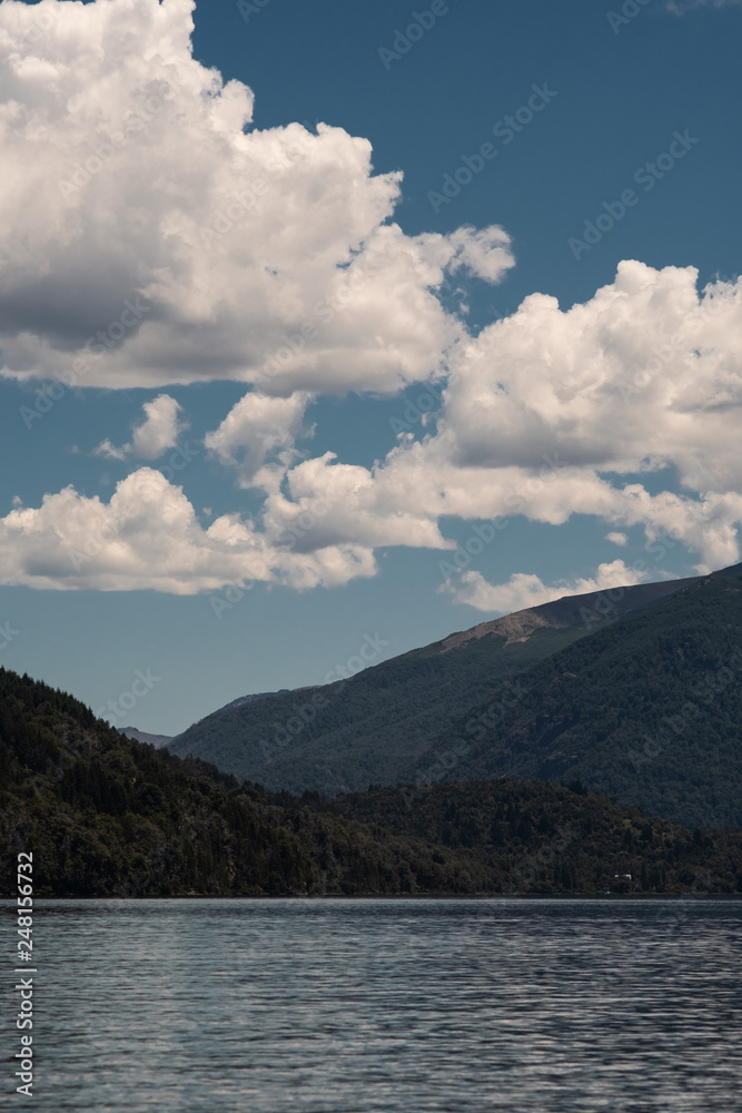 lake and mountains with clouds in the sky