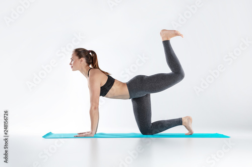Beautiful woman doing sport exercises on mat