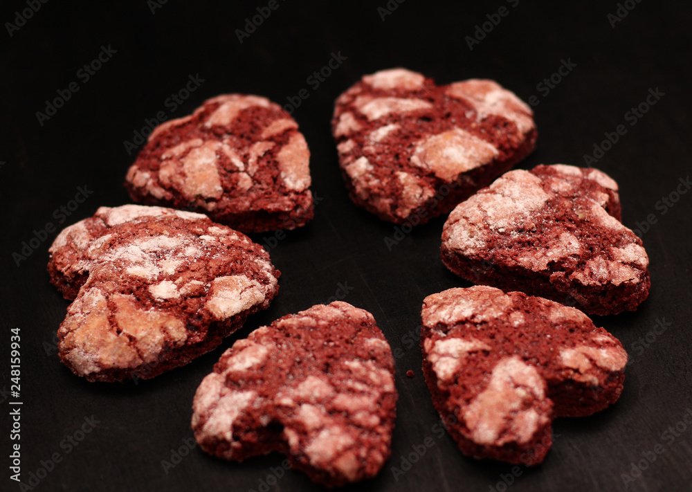 red chocolate cracked heart-shaped cookies on on a dark background. A gift for Valentine's Day, World Women's Day or Birthday