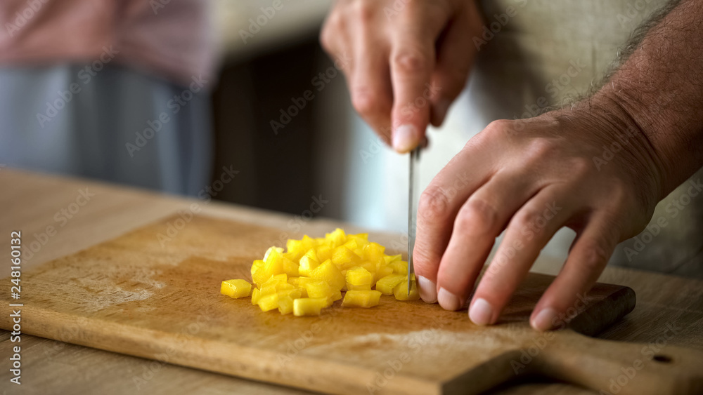 Male hands cutting yellow pepper on board, cooking fresh vegetable salad, food Male hands cutting yellow pepper on board, cooking fresh vegetable salad, food