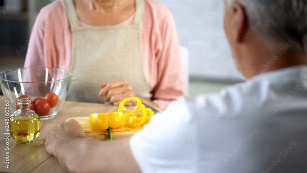 Mature wife and husband sitting at dinner table, cooking hobby, vegetarian meal Mature wife and husband sitting at dinner table, cooking hobby, vegetarian meal