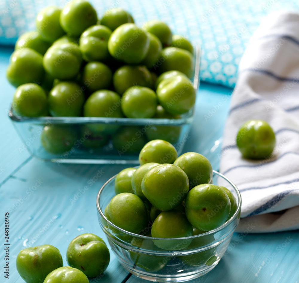Green cherry plums on wooden table Green cherry plums on wooden table