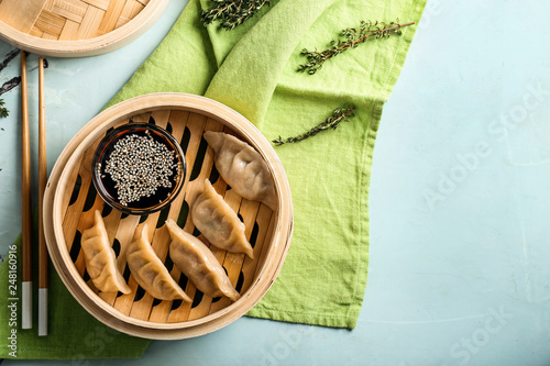 Bamboo steamer with tasty Japanese gyoza on table