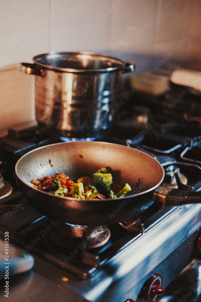 Vegetables cooking in frying pan on the gas stove