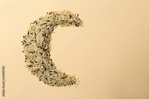 Half-moon made of rice as symbol of Islam on color background photo