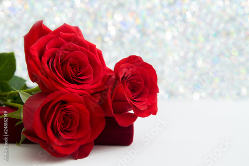 Three Red Roses and jewelery present box with boke Background. copy space - Valentines and 8 March Mother Women s Day concept.