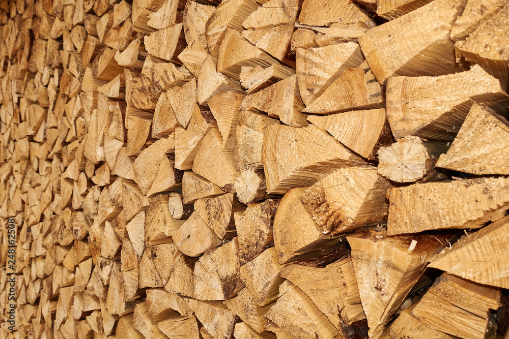 Background image of stacked, dry chopped logs used for firewood. Pile of logs ready to be used in fireplace. Alternative warming method. Background image of stacked, dry chopped logs used for firewood. Pile of logs ready to be used in fireplace. Alternative warming method.