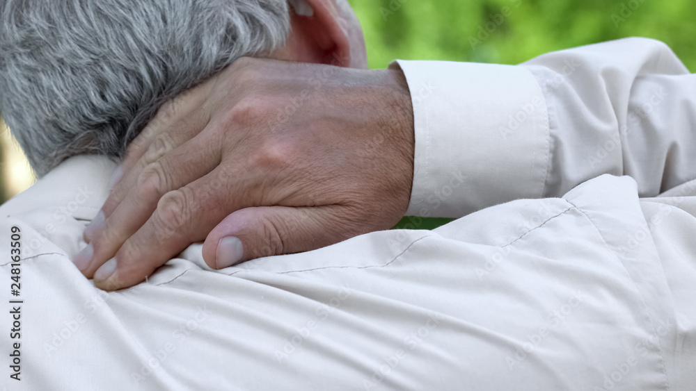 Fototapeta premium Man massaging numb neck, problems with spine, bad sleep conditions, healthcare
