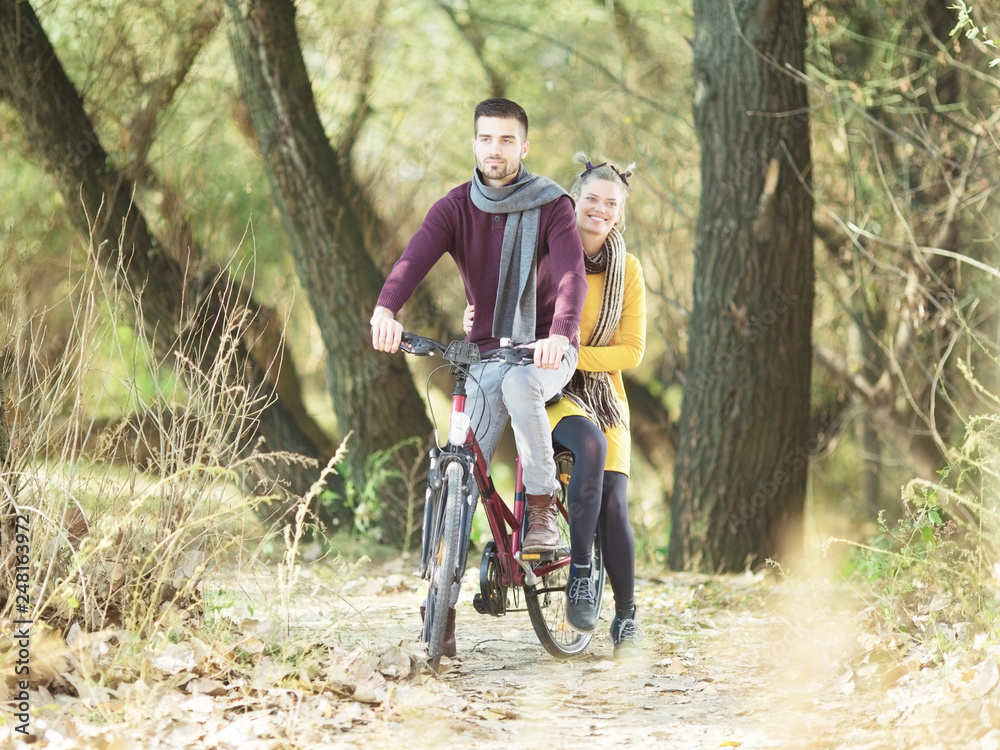 Naklejka premium Young beautiful couple on bicycle in nature