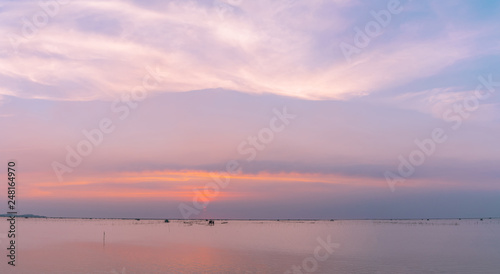 Beautiful sunset sky over the sea in the evening. Blue sky and purple, orange, and white clouds. Dramatic sky and clouds at the beach in Tropical sea at dusk. Seascape with sweet sky. Calm and relax.